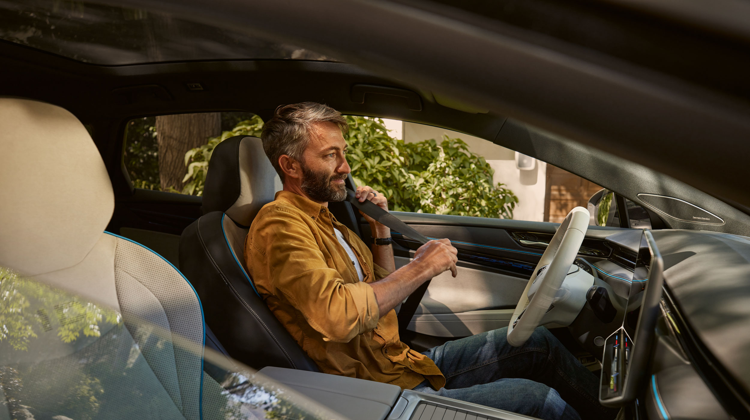 Glücklicher Mann lächelt und sitzt in seinem neu gekauften Auto